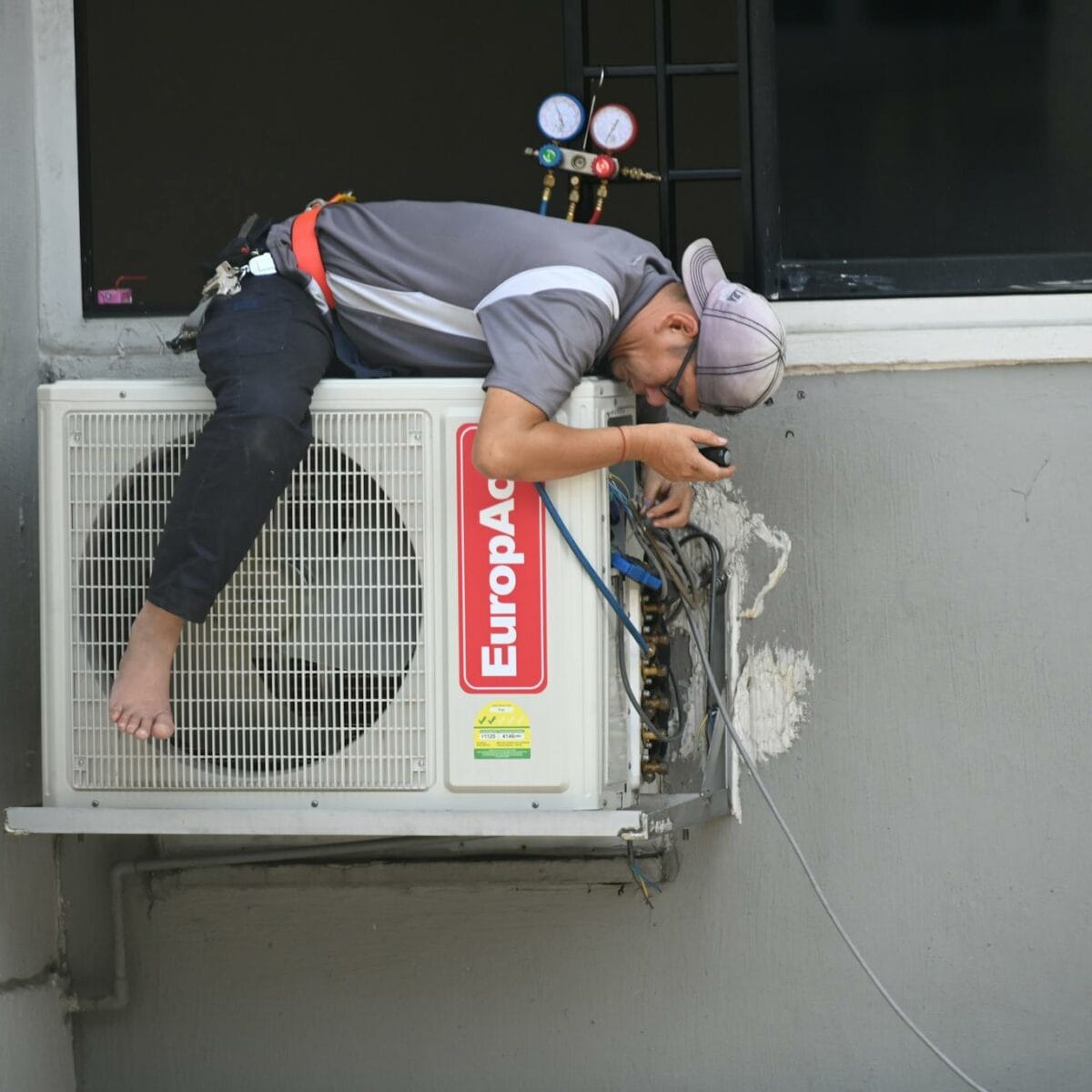Man in Gray T-shirt Fixing the Aircon