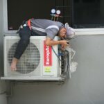 Man in Gray T-shirt Fixing the Aircon